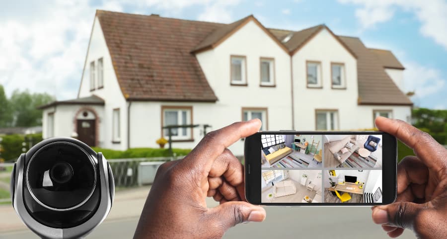 Man holding smartphone and viewing footage from security cameras